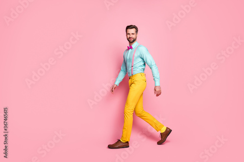Full length body size profile side view of his he nice attractive elegant luxury brandy funky cheery brunet guy walking corporate event isolated over pink pastel color background