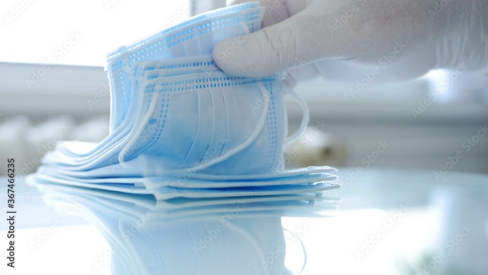 Doctor Verify a Pack of Surgical Masks by Checking Them One by One Doctor Verify a Pack of Surgical Masks by Checking Them One by One