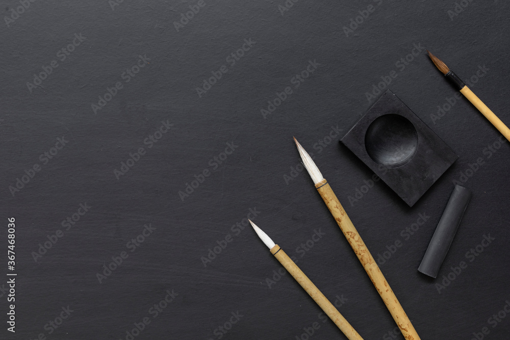 closeup Japan traditional writing brush on black table. top view. flat lay - obrazy, fototapety, plakaty 
