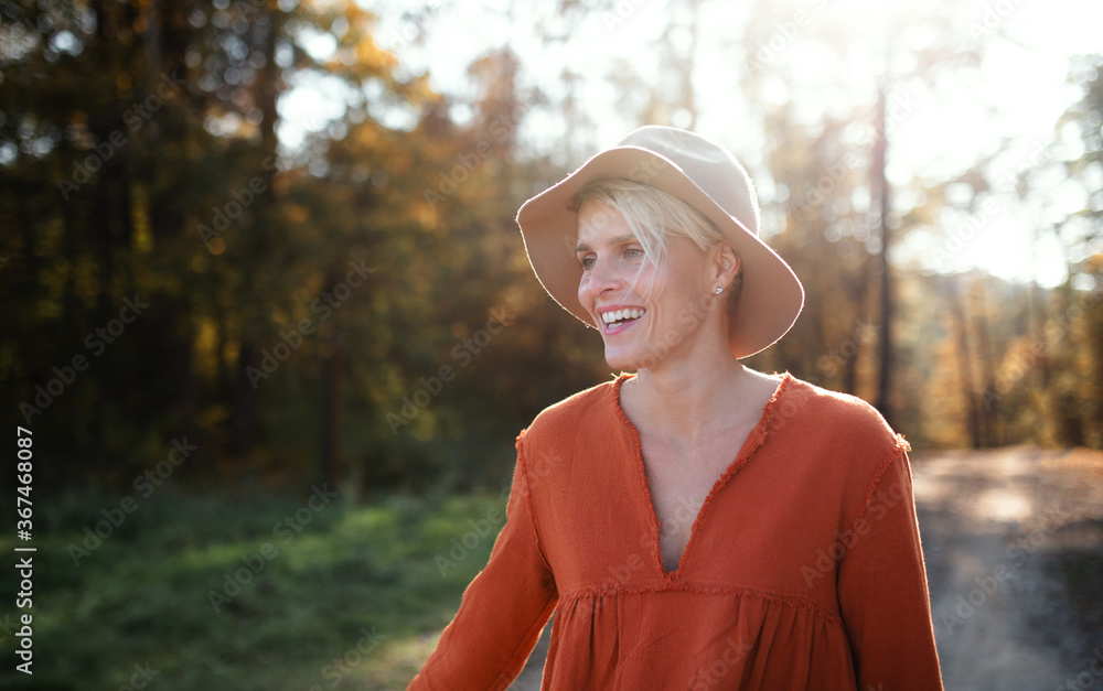 Portrait of young woman on a walk in autumn forest, walking.