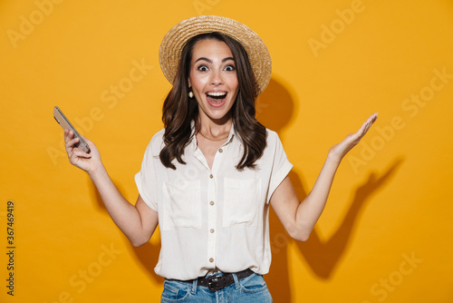 Image of excited woman holding cellphone and expressing surprise