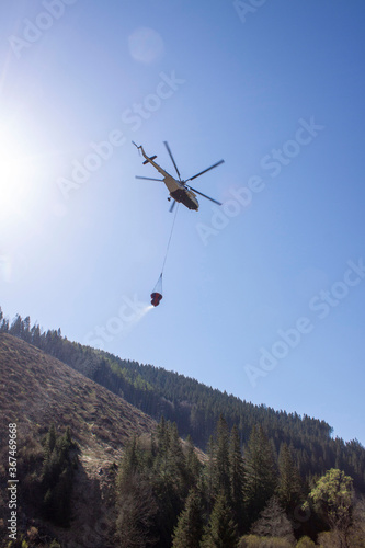 Specially adapted helicopter with water extinguishing bag. Firefighting efforts are currently underway with helicopters to suppress forest fires