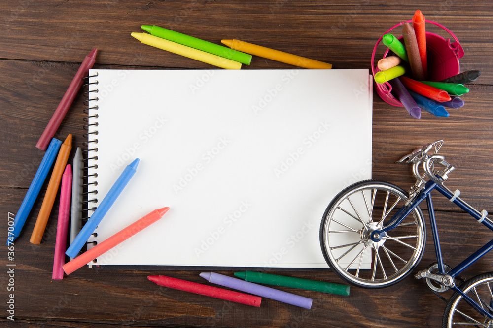 colored crayons and blank page on the wooden table colored crayons and blank page on the wooden table