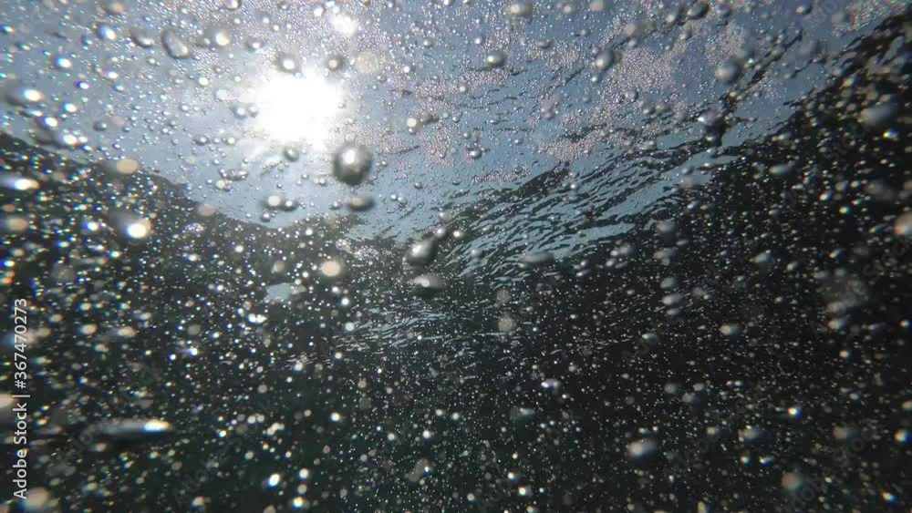 Air bubbles and rays of sunlight in the sea under water. Marine water background Air bubbles and rays of sunlight in the sea under water. Marine water background