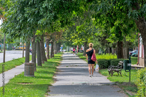 Beautiful woman walks through the city © banedeki1