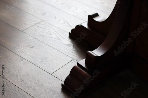 Wood carved tab. Carved oak underframe on a wooden floor. Dark wood. photo