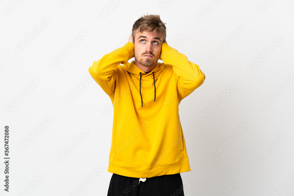 Young handsome man isolated on white background frustrated and covering ears Young handsome man isolated on white background frustrated and covering ears