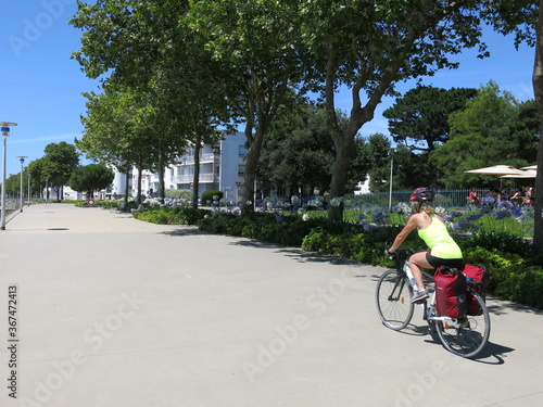 jeune femme cycliste à bicyclette avec sacoche pour randonnée à vélo sur piste cyclable le long de la Loire et en Bretagne