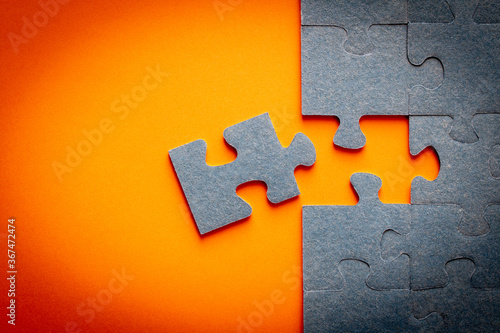 Puzzle. Many puzzle pieces on an orange background. The concept of collective thinking.