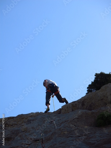 grimpeur qui escalade avec casque et corde