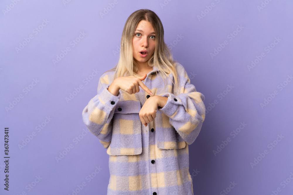Young blonde woman isolated on purple background making the gesture of being late Young blonde woman isolated on purple background making the gesture of being late