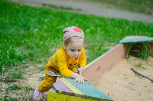 Photo of a blue-eyed toddler girl playing outside on the playground