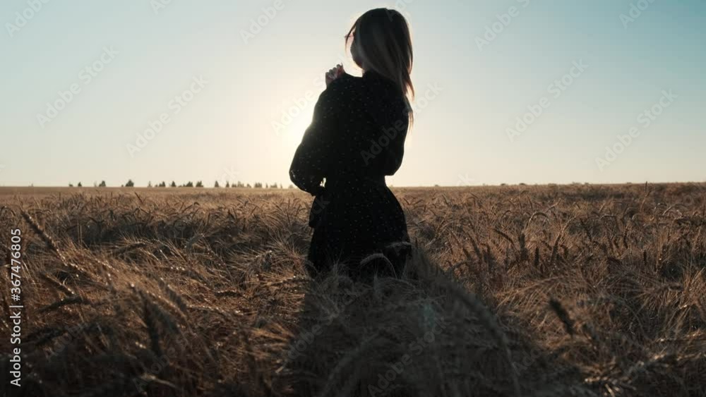 Beautiful blonde in a wheat field in a black dress. Beautiful sunset sun on a summer evening. Beautiful blonde in a wheat field in a black dress. Beautiful sunset sun on a summer evening.