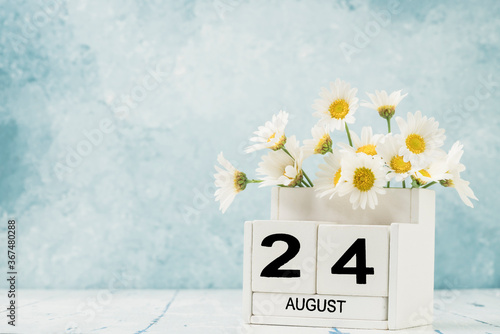 White cube calendar for august decorated with daisy flowers photo