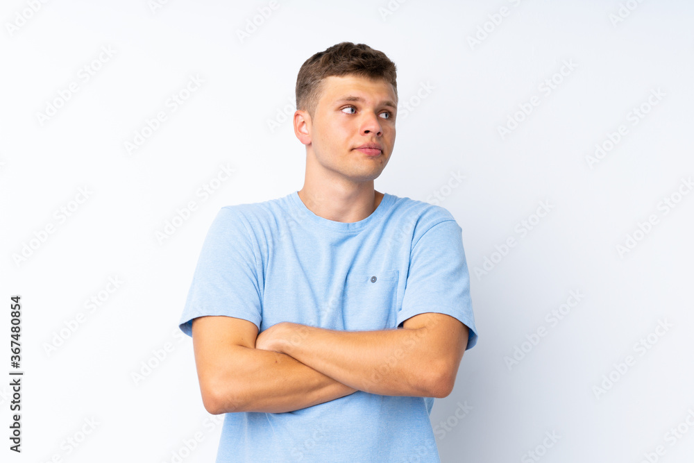 Young handsome man over isolated white background making doubts gesture while lifting the shoulders Young handsome man over isolated white background making doubts gesture while lifting the shoulders