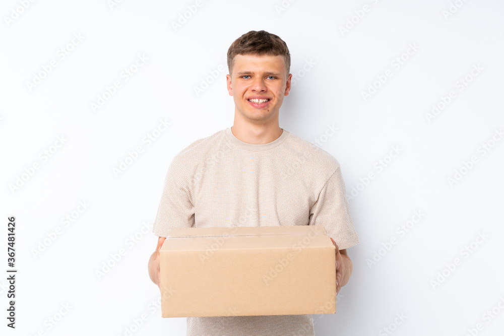 Young handsome man over isolated white background holding a box to move it to another site Young handsome man over isolated white background holding a box to move it to another site