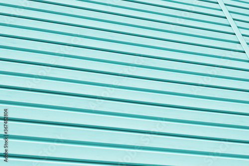 Striped plastic siding surface. Construction and renovation of buildings. Tinted light aquamarine or turquoise background or wallpaper. Building materials or technologies