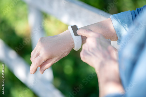 Elderly woman using smartwatch during her walk