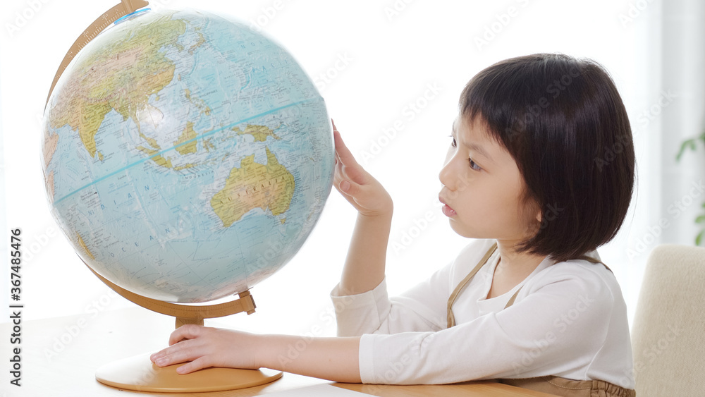 地球儀を見て勉強する子供