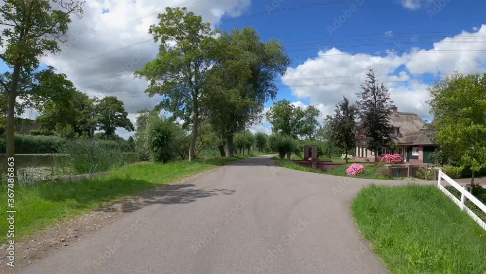 POV driving over dike at the river Amstel in Holland with Dutch houses POV driving over dike at the river Amstel in Holland with Dutch houses