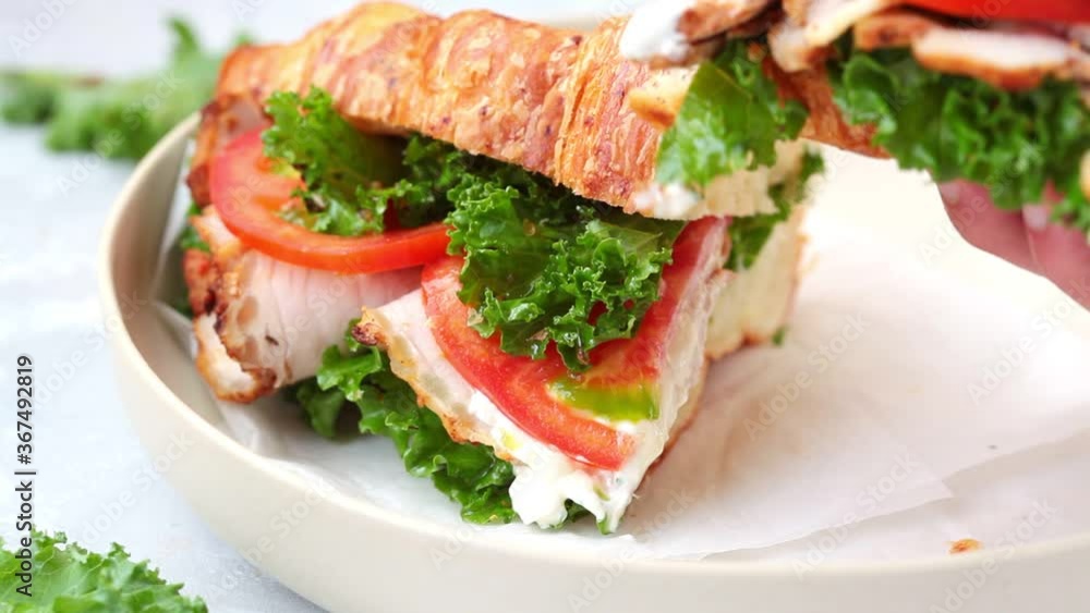 Croissant sandwich with meat, vegetables and green kale, white background. Breakfast food concept. Croissant sandwich with meat, vegetables and green kale, white background. Breakfast food concept.