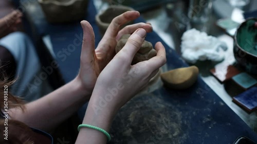 Human hands kneading clay, close-up. Pottery workshop concept.