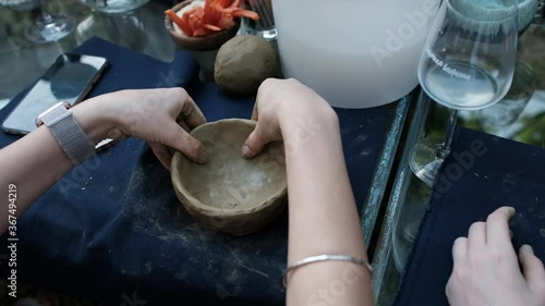 Close up of human hands making a bowl from clay. Pottery teaching class.