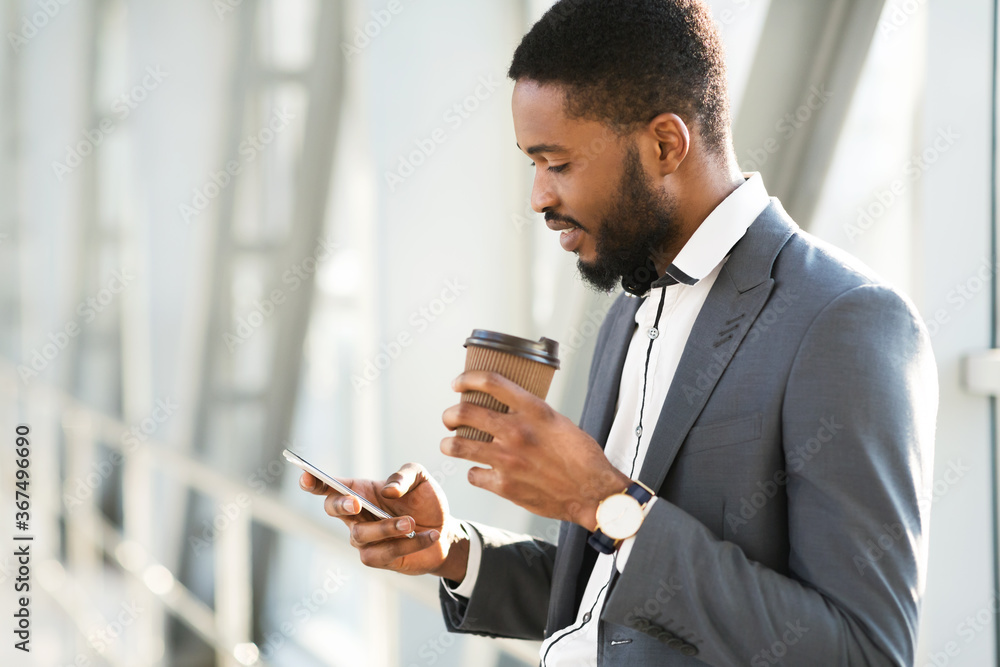 Happy African Businessman Using Cellphone Having Coffee In Airport Terminal Happy African Businessman Using Cellphone Having Coffee In Airport Terminal