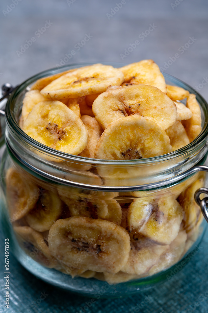 Healthy snack, crispy dehydrated unsugared banana chips in glass jar Healthy snack, crispy dehydrated unsugared banana chips in glass jar