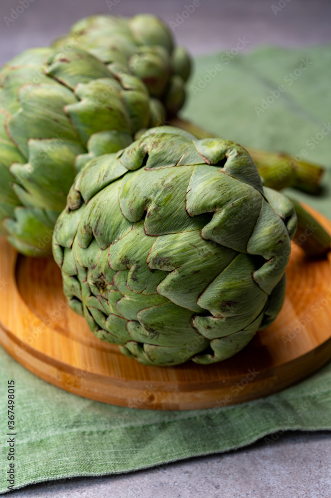 Fototapeta premium Big ripe uncooked green globe artichoks vegetables