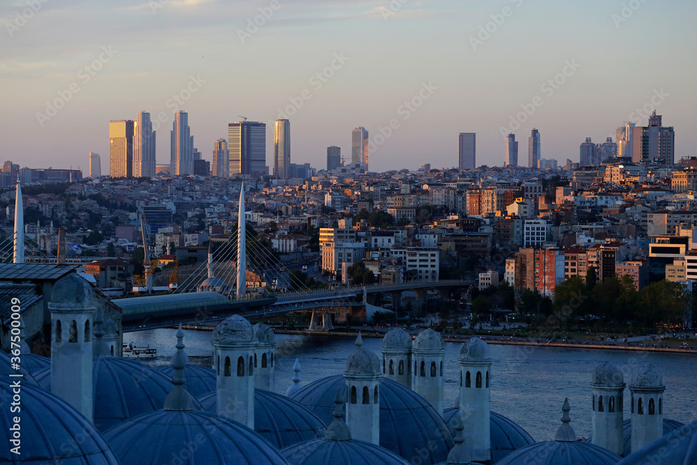 Fototapeta premium The Halic Metro bridge, left, and the skyline of the european side of Istanbul, Turkey, are seen in a photo taken from Suleymaniye mosque during a summer afternoon.