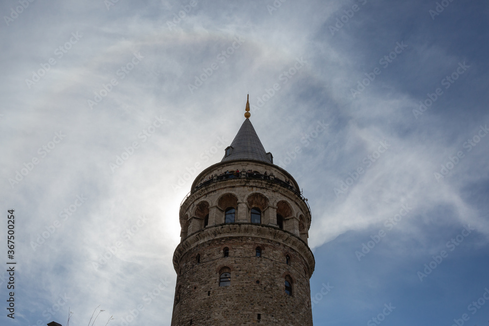Worms eye view of Galata Tower with partial cloudy sky in Istanbul, Turkey.