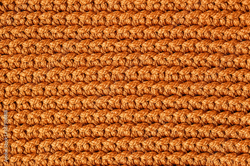 Orange knitted fabric texture background. Top view. Copy, empty space for text