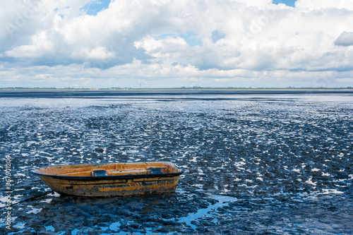 Obraz na plátně a single boat in the wadden sea at ebbe