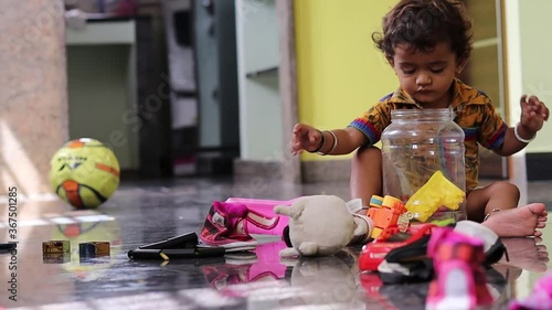 A child playing with toys in an empty box