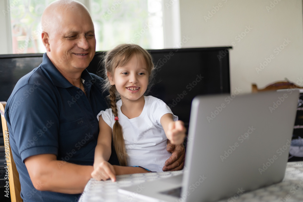 Portrait of grandfather and granddaughter doing homework with laptop. Portrait of grandfather and granddaughter doing homework with laptop.
