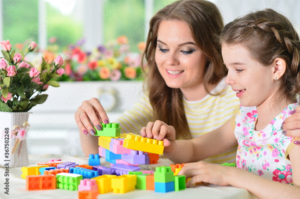 Girl with mother playing with colorful plastic blocks Girl with mother playing with colorful plastic blocks