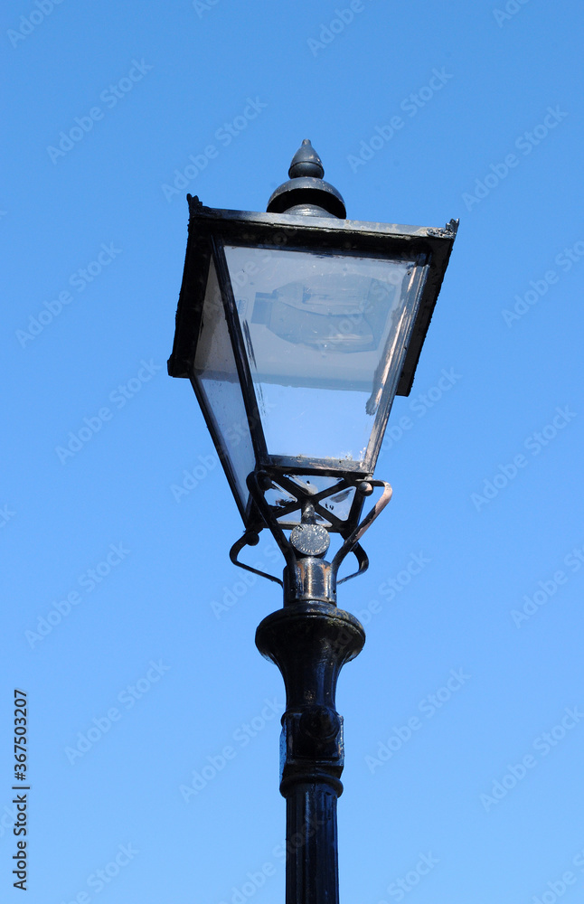 Fototapeta premium Traditional Iron Street Light seen from Below against Blue Sky 