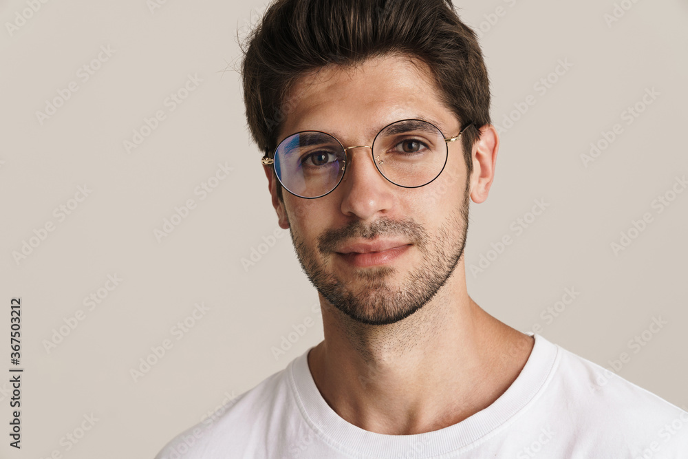 Obraz premium Image of confident young man in eyeglasses posing and looking at camera