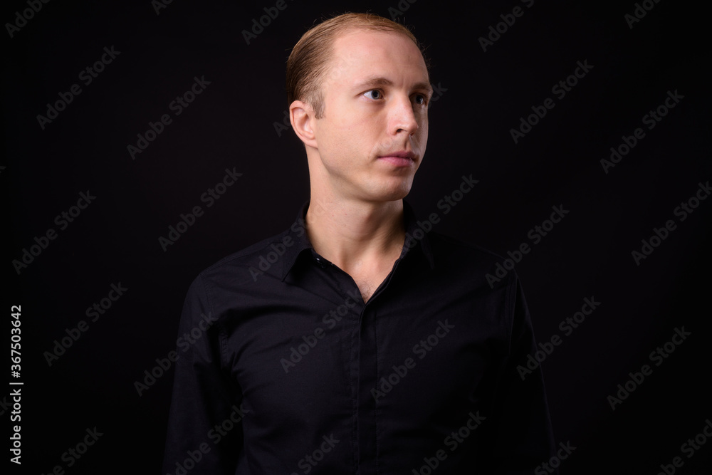 Businessman with blond hair against black background Businessman with blond hair against black background