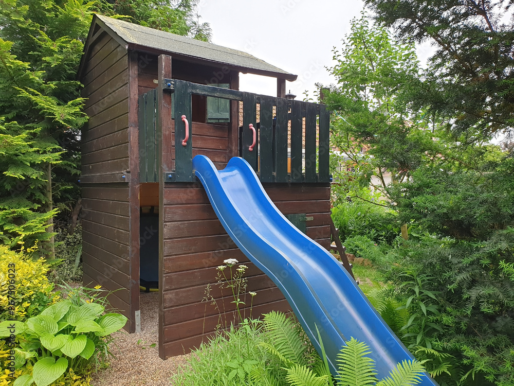 Kinder Holzhaus mit Rutsche im Garten Stock Photo Adobe Stock