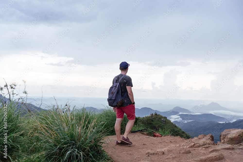 Man enjoying pristine nature and beautiful view of tea plantations from the top of Small Adams peak near Ella, Sri Lanka. Tracking outdoors tourist adventure.
