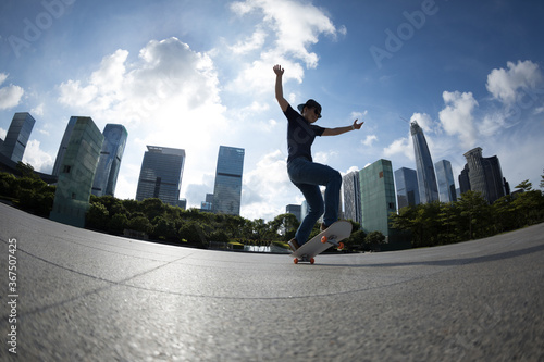 Asian woman skateboarder skateboarding in modern city