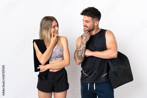 Young sport couple isolated on white background looking looking at each other