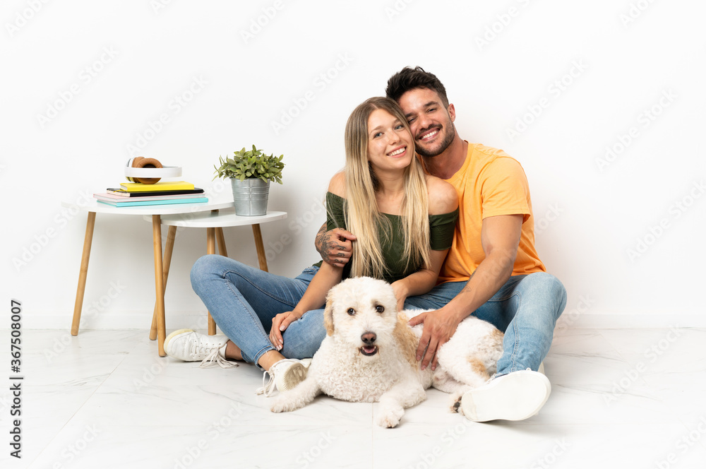 Young caucasian couple with dog staying at home hugging Young caucasian couple with dog staying at home hugging