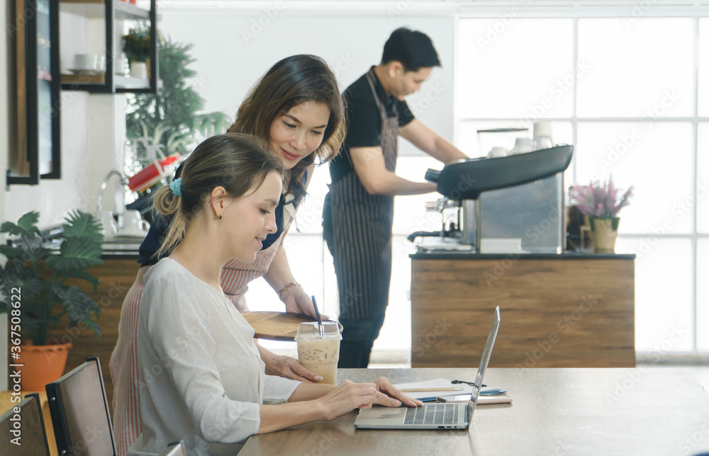 Young female customers use laptops in the cafe. Young female customers use laptops in the cafe.