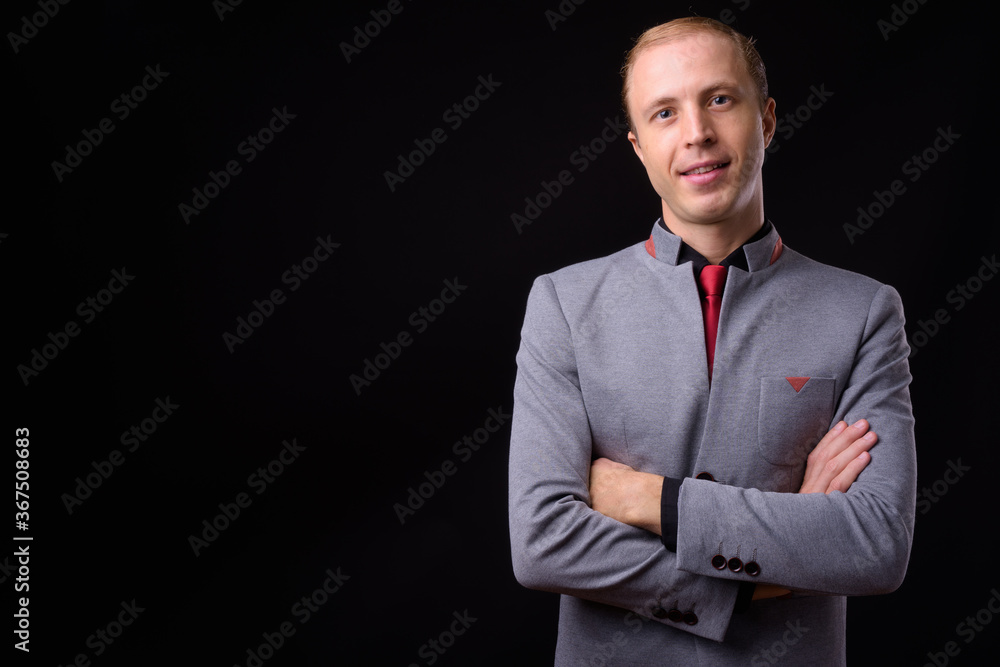 Businessman with blond hair against black background Businessman with blond hair against black background
