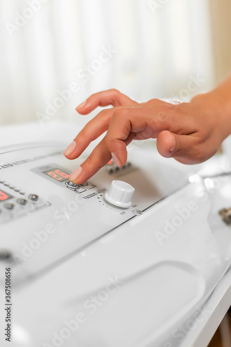 Massage specialist woman's hand adjusts vacuum machine for anti-cellulite massage. Lipomassage machine. massage in the beauty salon. Anticellulite massage.