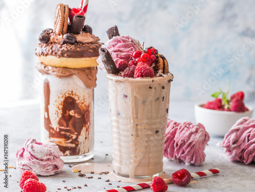 Chocolate indulgent frosting exreme milkshake with donut  and sweets. Crazy freakshake food trend. Copy space photo