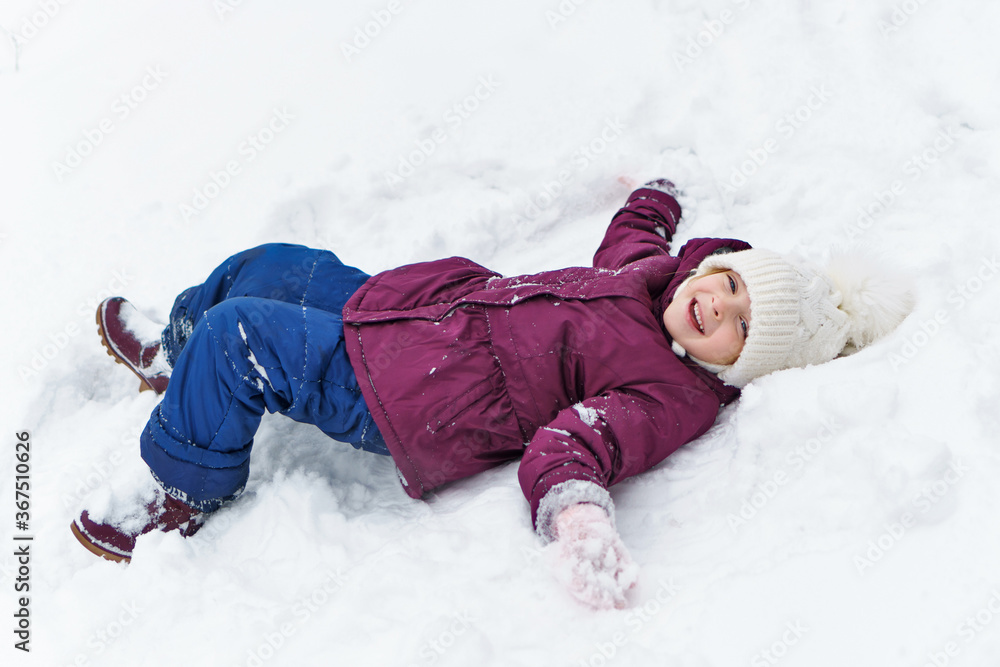 Full length portrait of a little playful girl in the snow. She has fun and leads a healthy lifestyle. Walk on a winter snowy day. Happy childhood. Games, freedom and carefree Full length portrait of a little playful girl in the snow. She has fun and leads a healthy lifestyle. Walk on a winter snowy day. Happy childhood. Games, freedom and carefree
